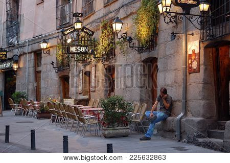A Young Man Has A Call In Front Of The Meson Rincon De La Cava Tapas Restaurant Off Plaza Mayor - Ma