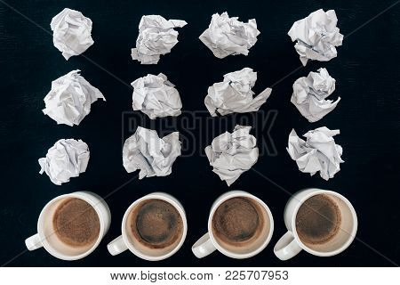 Top View Of Crumpled Papers And Cups Of Coffee In Rows Isolated On Black