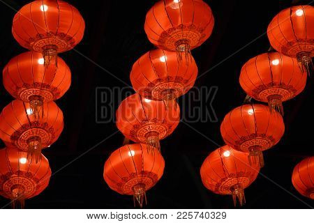 Chinese Red Lantern Lamps Hanging From A Ceiling Lit Up At Night