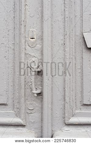 Close-up Keyholes With Curtains And A Handle On The Gray Many Times Painted Cracked Double-barreled 