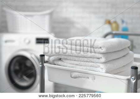 Stack of clean towels on cart in laundromat