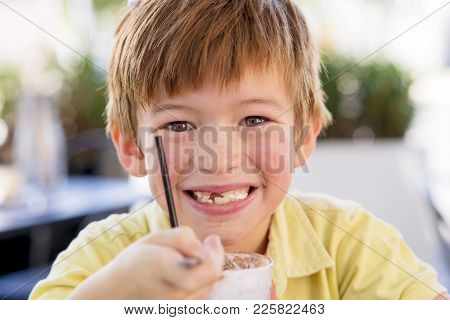 Head Portrait Of Lovely And Sweet Young Kid 7 Or 8 Years Old In Yellow Shirt  Enjoying Happy Drinkin