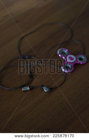Close Up Top View Photo Of Headphones And Modern And Hot Toy Fidget Spinner