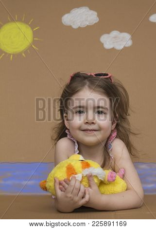 Summer Vacation. Cute Little Girl Play On Summer Beach. Background Of Painted Sun, White Clouds And 