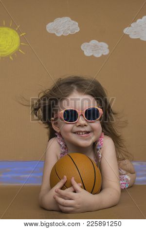 Summer Vacation. Cute Little Girl Play On Summer Beach. Background Of Painted Sun, White Clouds And 