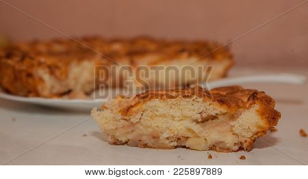 Fresh Slice Of Apple Pie With Whole Pie In Background.