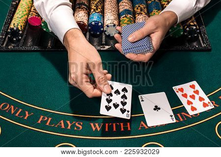 Casino, Gambling, Poker, People And Entertainment Concept - Close Up Of Holdem Dealer With Playing C