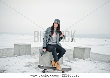 Stylish Brunette Girl In Gray Cap, Casual Street Style With Skate Board On Winter Day.