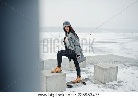 Stylish Brunette Girl In Gray Cap, Casual Street Style With Skate Board On Winter Day.