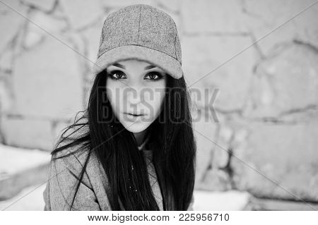 Stylish Brunette Girl In Gray Cap, Casual Street Style On Winter Day Against Colored Wall.