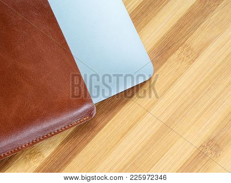 A Laptop Computer In A Leather Case On The Table