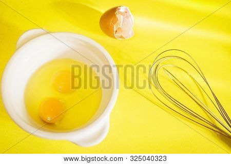 Egg Yolks With Egg Shells And Whisk On Yellow Silestone