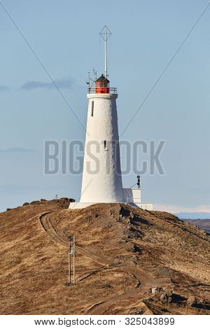 Reykjanes Lighthouse in Iceland with Gunnuhver geotermal area in the background