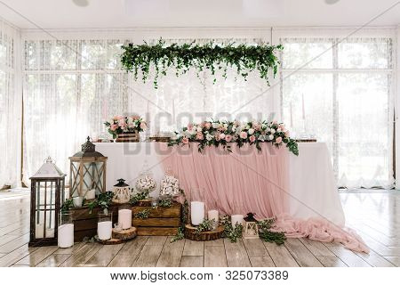 Beautiful Groom And Bride Table Near Large Light Windows Decorated With Natural Materials