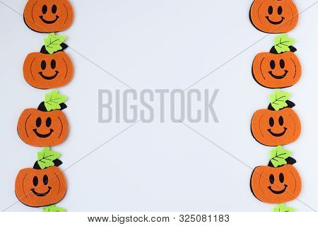 Top View Of Halloween Crafts, Felt Handmade Pumpkins On White Paper Background . Halloween Concept. 