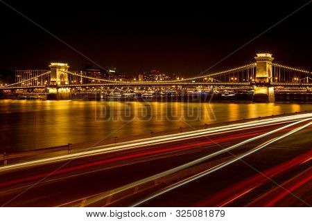 The Famous Széchenyi Chain Bridge In Budapest, Hungary, Illuminated Above The Danube River. Long Exp
