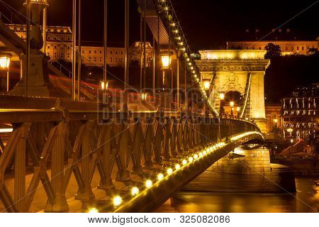 The Famous Széchenyi Chain Bridge In Budapest, Hungary, Illuminated Above The Danube River. Long Exp