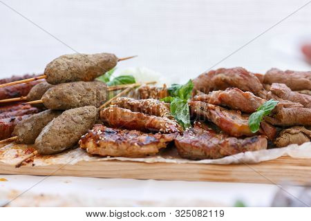 A Front View Of Juicy Meaty Barbeque With Lula Kebabs On The Wooden Sticks And Mint Leafs As The Top