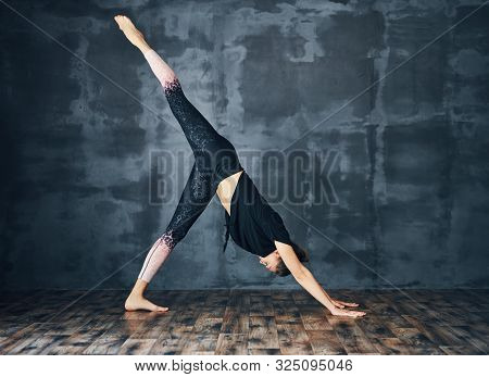 Young Sporty Woman Practicing Yoga, Doing One Legged Downward Facing Dog Pose Eka Pada Adho Mukha Sv