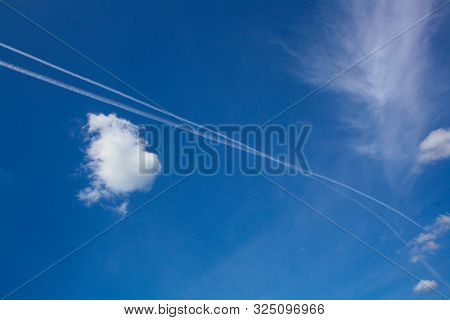 Intersecting Aircraft Tracks In The Sky Among The Clouds.