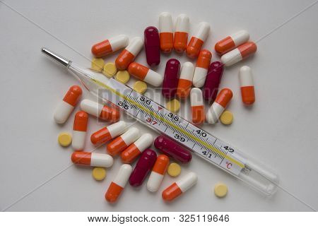 Concomitant Illness - Thermometer And Medicines On White Background.