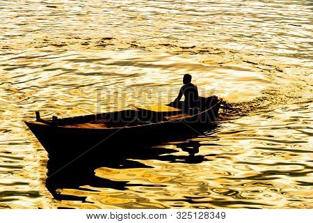 Silhouette Of Boatman At The Time Of Sunset - Lake ,boatman Sailing On His Wooden Boat