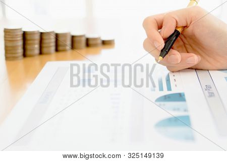 A Businesswoman Analyzing Financial Graph With Coins