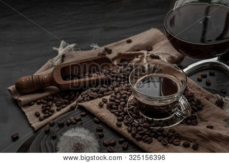 Coffee Style, Cup Of Coffee And Coffee Beans Roating With Old Wooden Scoop And Coffee Beans Around O