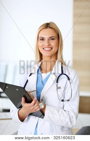 Doctor Woman At Work In Hospital Excited And Happy Of Her Profession. Blonde Physician Controls Medi