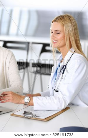 Doctor Woman At Work In Hospital Excited And Happy Of Consulting Female Patient. Blonde Physician Co