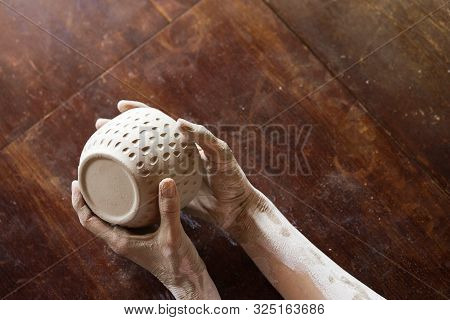 Female Hands Hold A Wet Clay Bowl. Pottery Making