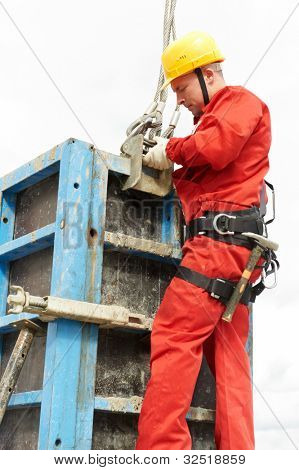 worker mounter assembling concrete formwork at construction site