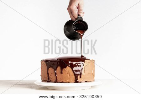 Glazing Chocolate Cake With Melted Chocolate. Woman Pouring Chocolate Over Cake. Homemade Cocoa Laye