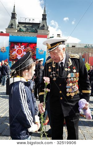 モスクワは-5 月 9 日： 第二次世界大戦ベテラン海軍の制服の少年と手の会談でカーネーションを