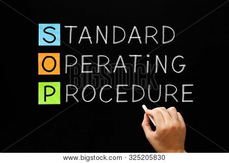 Hand Writing Sop Standard Operating Procedure Concept With White Chalk On Blackboard.