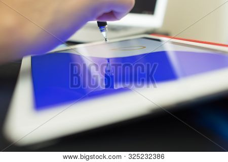 A Person Drawing Something On A Tablet.