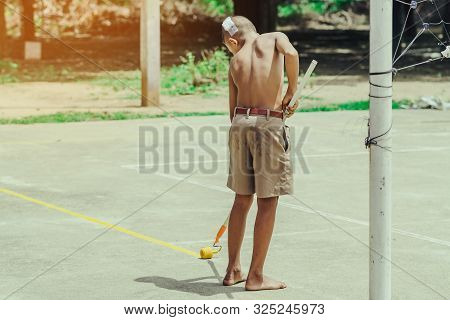 Male Students Use Small Paint Rollers To Paint Yellow Lines On The Cement Floor For Sepak Takraw Tra