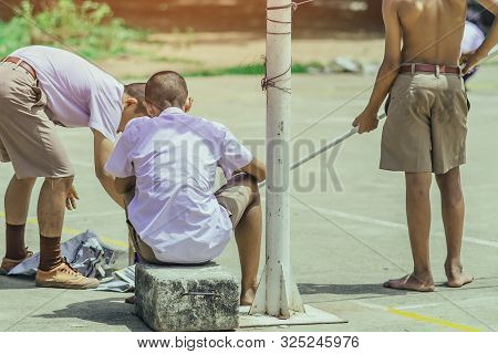 Male Students Use Small Paint Rollers To Paint Yellow Lines On The Cement Floor For Sepak Takraw Tra