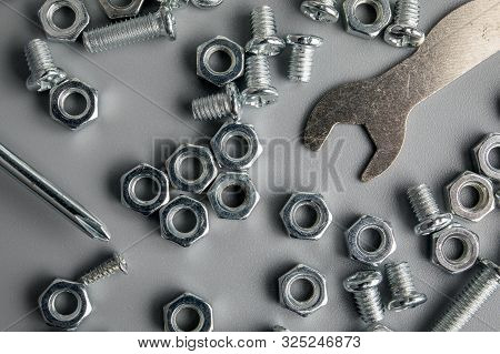 Metal Bolts And Nuts In A Gray Background. Chromed Screw Bolts And Nuts. Set Of Nuts And Bolts