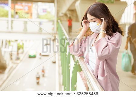 Asian Business Woman Wearing A Protective Face Mask On A City Street With Air Pollution. Facial Hygi