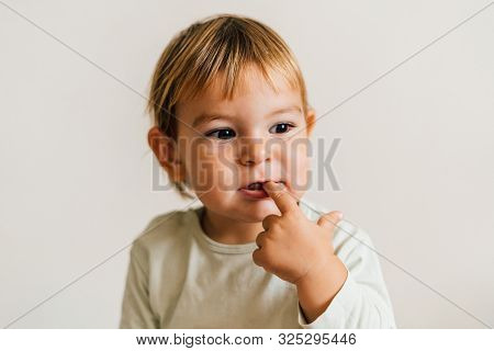 Toddler With Finger In Her Mouth. Teething Snore Gums Concept. Sucking Finger