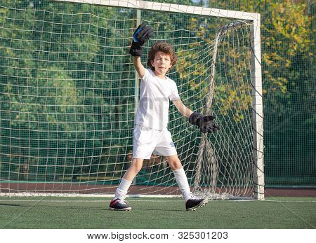 Young Goalkeeper On An Outdoor Court Standing In The Football Gate. Football, Soccer Player. Goalkee