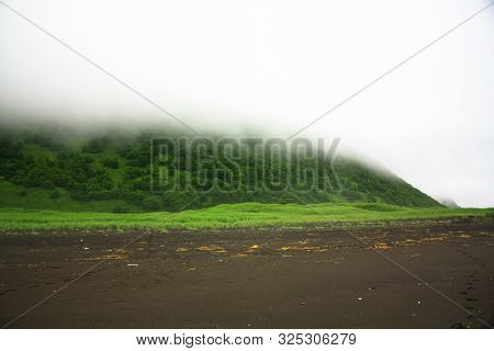 Fog On The Ocaen Beach With Dark Sand In Cloudy Weather