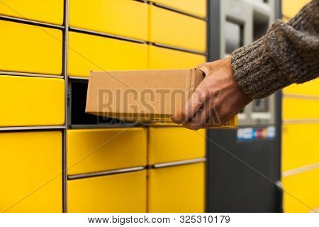 Yellow Self-service Post Terminal Machine. Man Recieve A Parcel