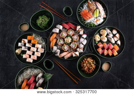 Assorted Sushi Set Served On Dark Stone Slate Background. Top View Of Wakame Salad, Seafood,various 