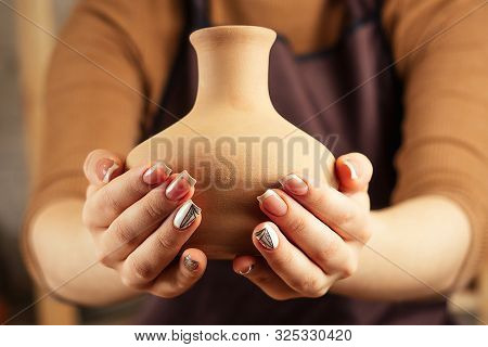Brown Vase From Clay In The Potters Hands Close Up. A Young And Cheerful Woman Holding A Vase Of Cla