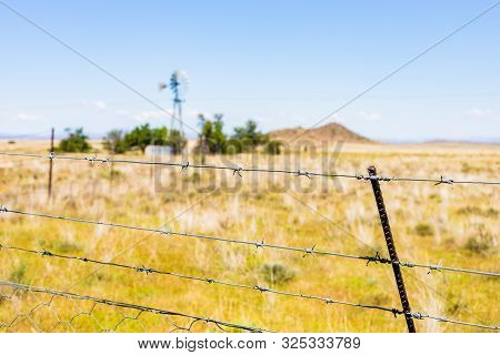 Windmill On A Farm In Rural Grassland Area Of South Africa