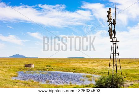 Windmill On A Farm In Rural Grassland Area Of South Africa