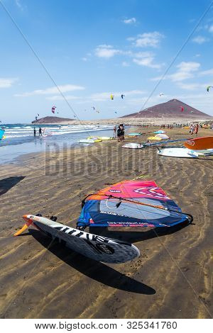 El Medano, Spain - July 7 2019: People Surfing, Kiting And Windsurfing On Playa De Leocadio Machado