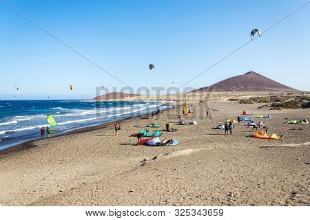 El Medano, Spain - July 7 2019: People Surfing, Kiting And Windsurfing On Playa De Leocadio Machado